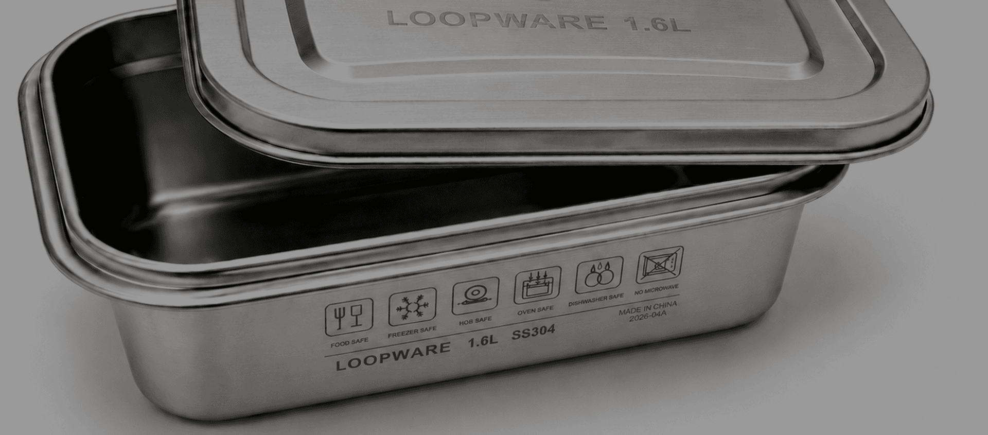 The engraved use icons and SS304 grade on a Loopware stainless steel container, in low light